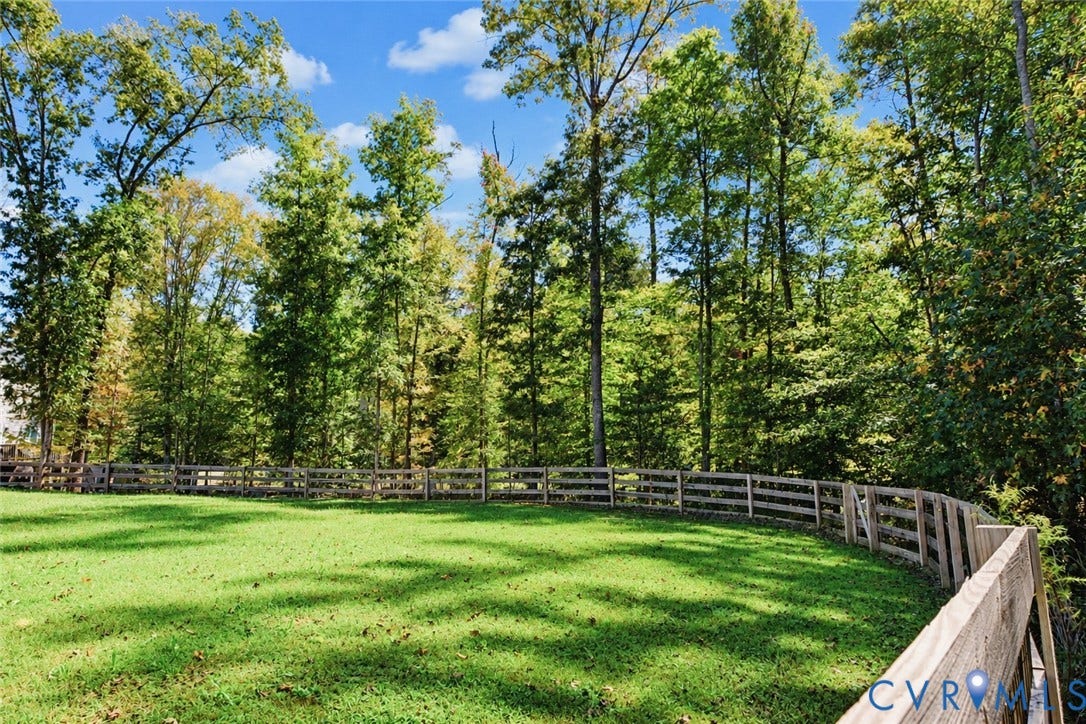 6265 Bushnell Drive, Rochambeau Estates, New Kent, VA 23124 Expansive green lawn with a wooden split-rail fence and mature trees