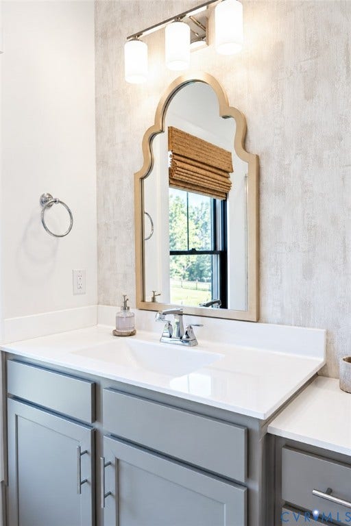 6265 Bushnell Drive, Rochambeau Estates, New Kent, VA 23124 White countertop with an integrated rectangular sink, chrome faucet, and gray cabinetry with brushed nickel hardware