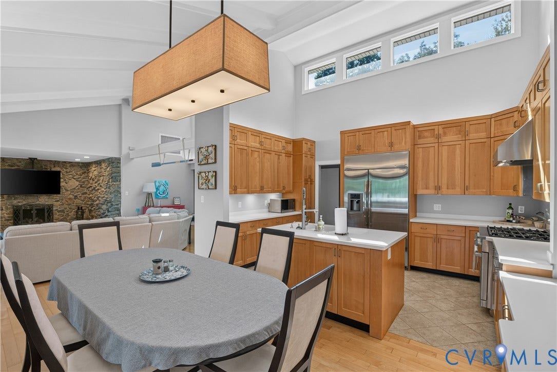 Kitchen featuring wood-finish cabinetry, stainless steel appliances, and a central island with a sink