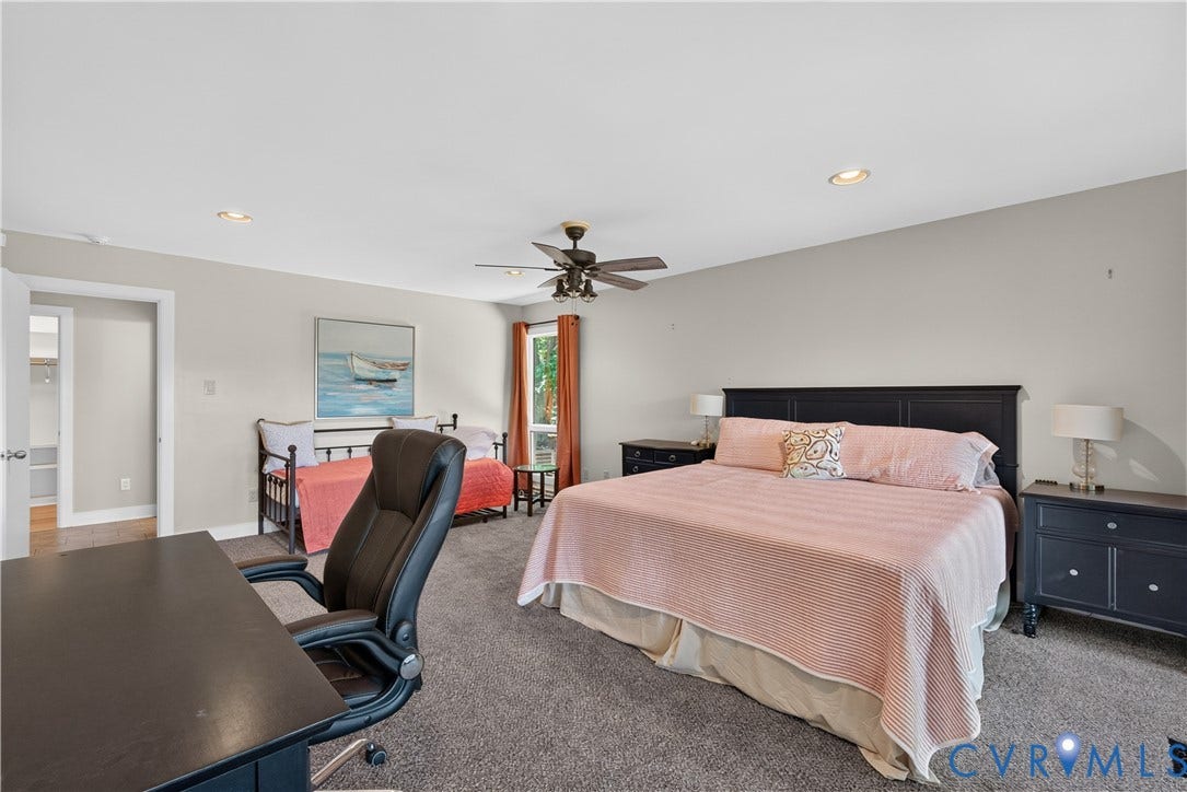 Recessed ceiling lighting, ceiling fan, carpet flooring, window with natural light, and a closet with built-in shelving