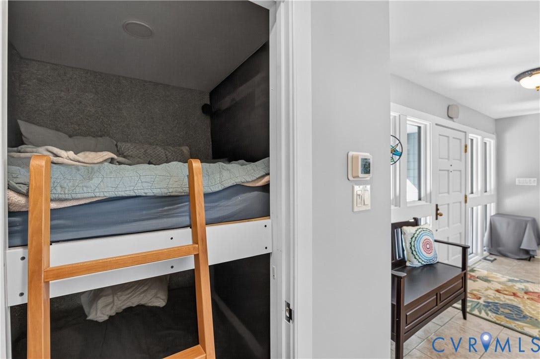 Built-in bunk bed with ladder, tile flooring, and a white front entry door with side lites