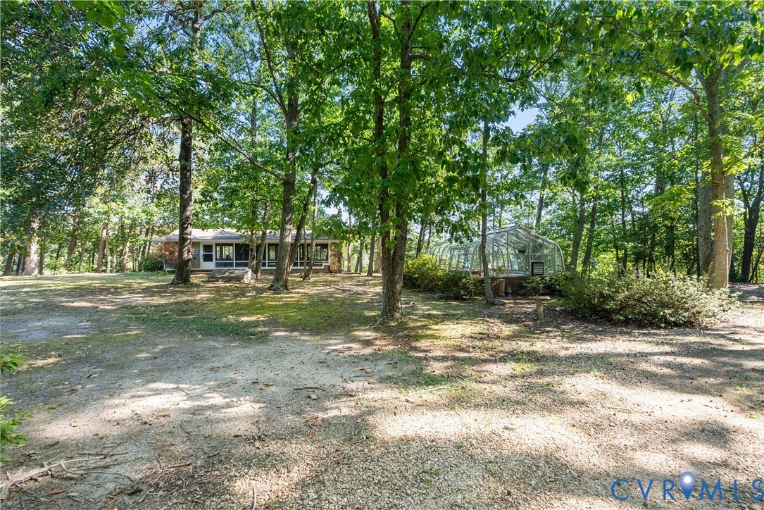 Expansive property featuring mature trees and a detached greenhouse
