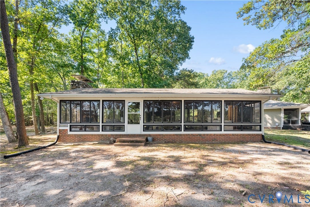 Enclosed porch with extensive windows, brick base, and white trim