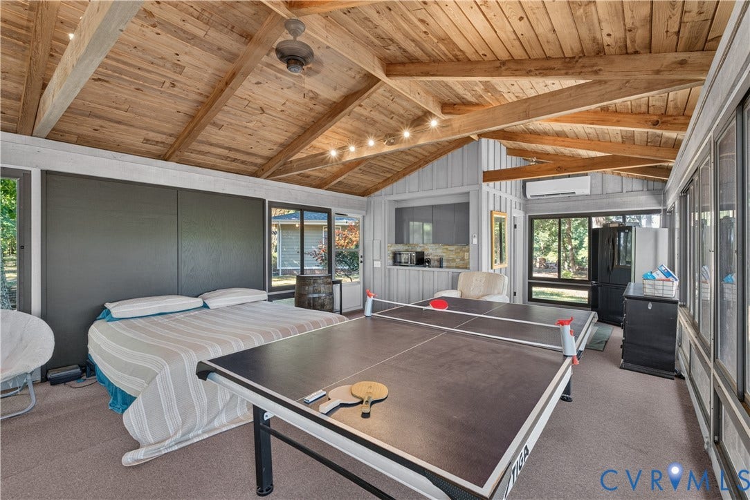 Vaulted wood-plank ceiling with exposed beams, recessed lighting, and a ceiling fan