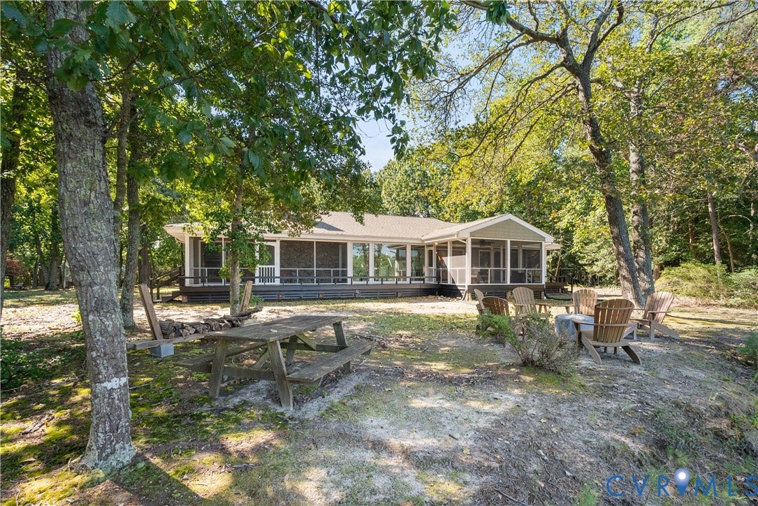 Ranch-style exterior with a screened porch, covered porch, and mature trees