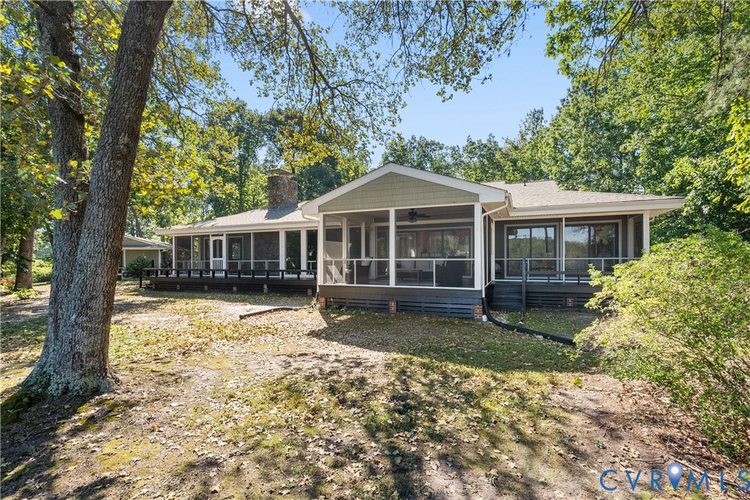 Expansive rear facade featuring a screened porch, covered deck, and multiple sliding glass doors