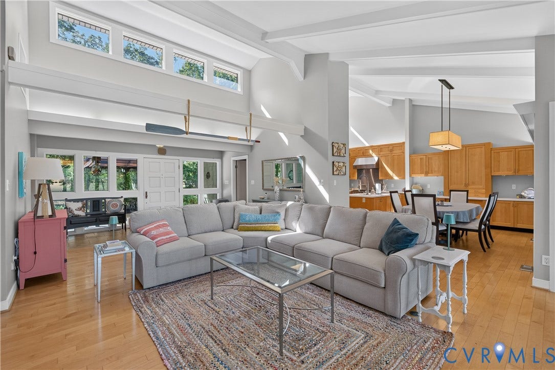 Vaulted ceilings with exposed beams, wood-finish flooring, white double French doors, transom windows, and recessed lighting