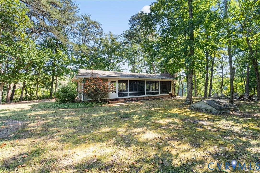 Screened porch with white framing, surrounded by mature trees