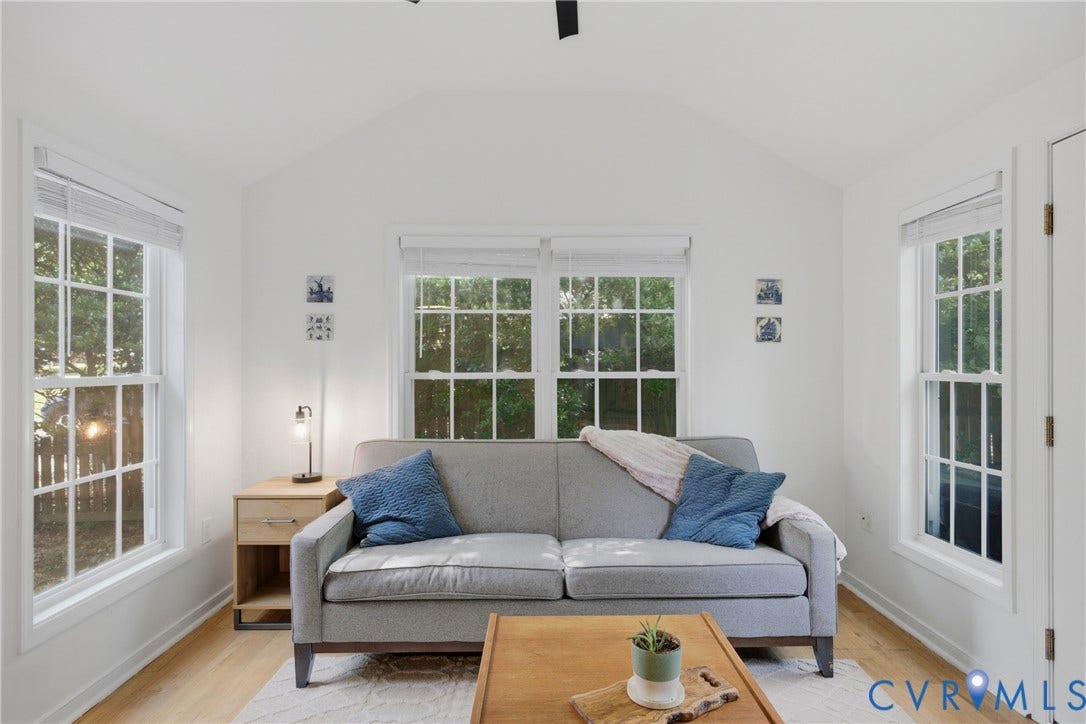 Vaulted ceiling with a ceiling-mounted light fixture, hardwood flooring, minisplit