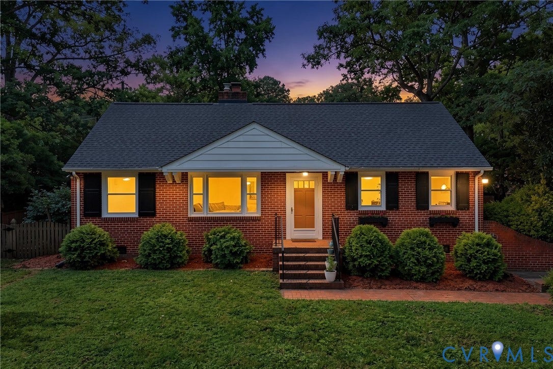Brick exterior with black shutters, dark shingle roof, and a front entry porch