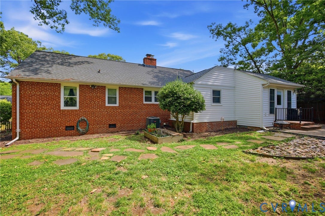 Red brick exterior with white trim windows and a black shingle roof