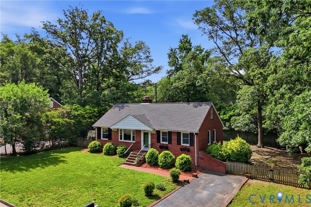 Brick exterior with dark shutters, gabled roofline, and front entry with steps