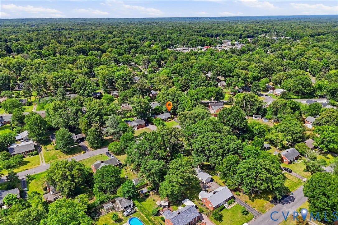 Aerial perspective showcasing a residential area amidst extensive mature tree coverage