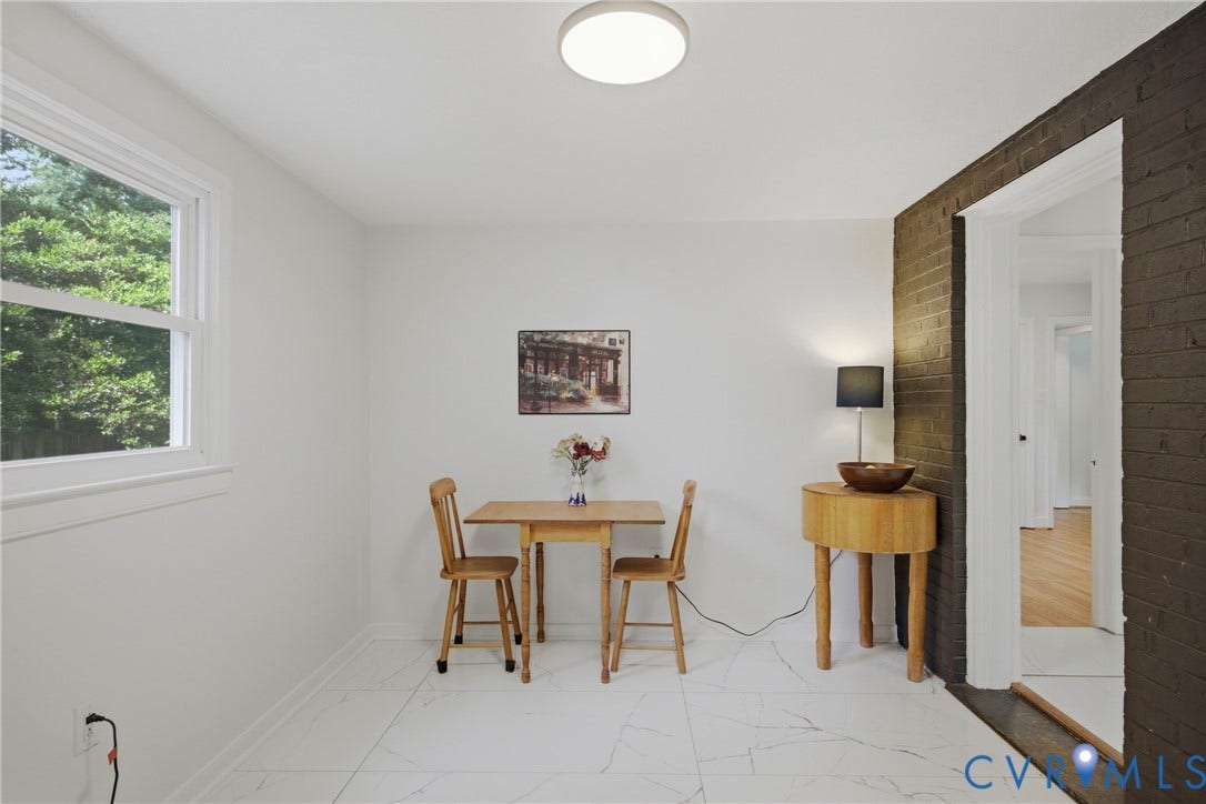 White tile flooring, exposed brick wall, pass-through window,  and minisplit