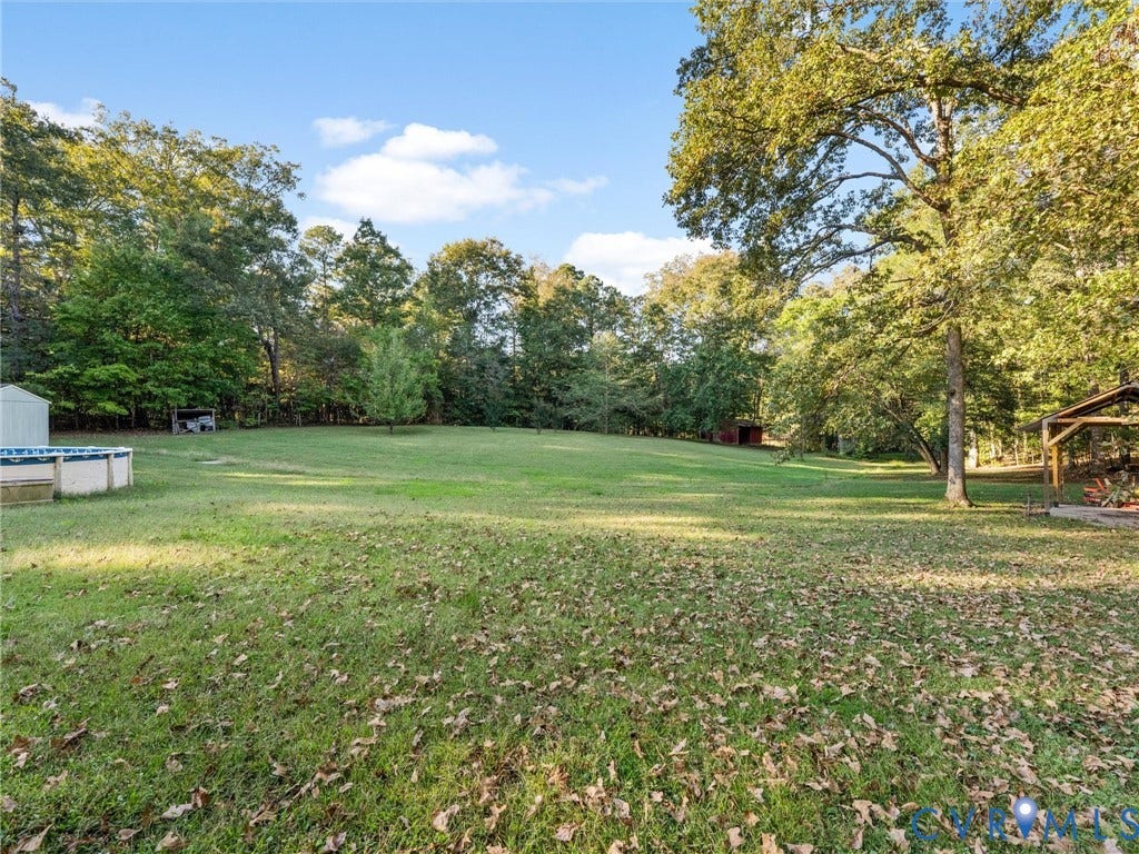 8251 Old Roxbury Road, Quinton, VA 23141 Expansive backyard featuring a large grass lawn, mature trees, and a wooden gazebo structure