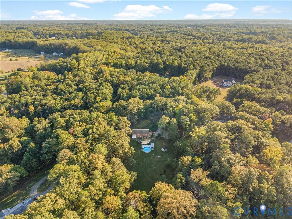 8251 Old Roxbury Road, Quinton, VA 23141 Aerial view of a sprawling property featuring extensive wooded acreage, a cleared lawn, and a circular above-ground pool