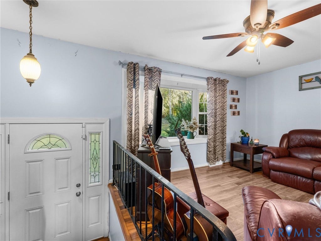 8251 Old Roxbury Road, Quinton, VA 23141 Entryway featuring a white door with a decorative glass sidelight, wood-finish flooring, metal railing, bay window with a built-in sill, and a multi-light ceiling fan