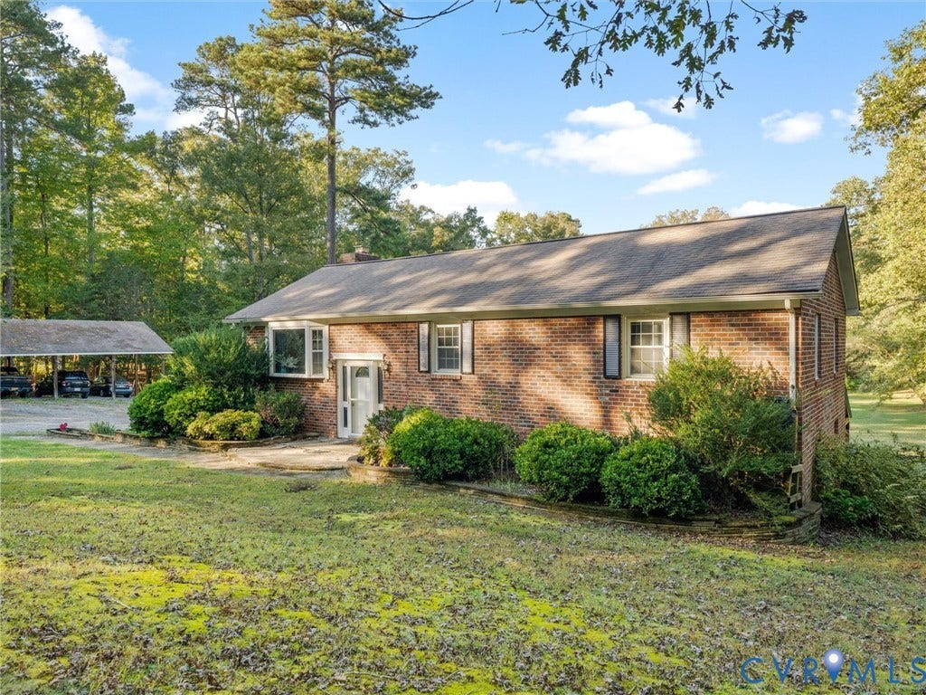 8251 Old Roxbury Road, Quinton, VA 23141 Brick exterior residence featuring a gable roof, bay window, stone-accented front patio, and detached covered parking structure