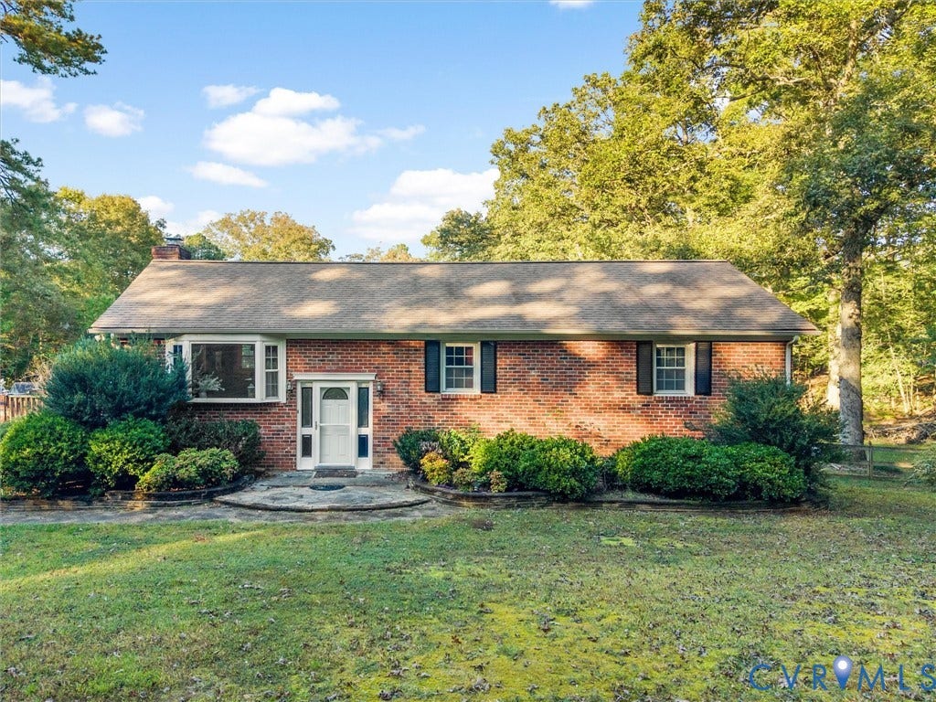8251 Old Roxbury Road, Quinton, VA 23141 Red brick exterior featuring a multi-pane bay window, shutters, an arched front entryway, and stone hardscaping