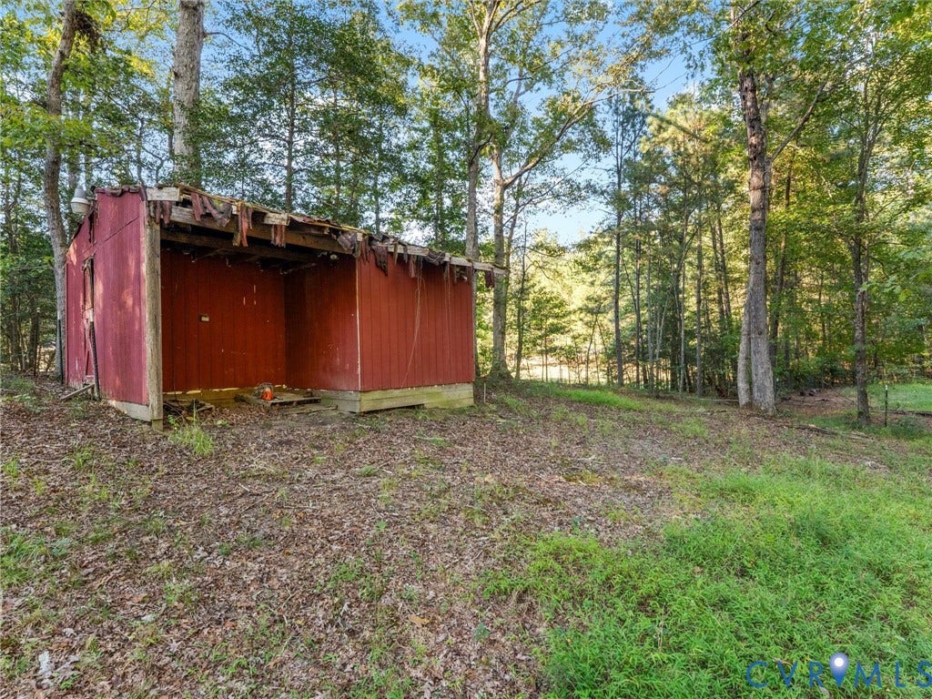 8251 Old Roxbury Road, Quinton, VA 23141 Exterior storage structure featuring wood-panel siding, a metal roof, and an open-front design situated on a wooded lot