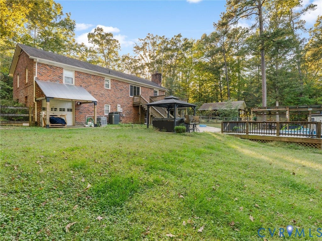 8251 Old Roxbury Road, Quinton, VA 23141 Brick exterior home featuring a covered side entry, wood deck, fenced backyard, and a detached wooden structure