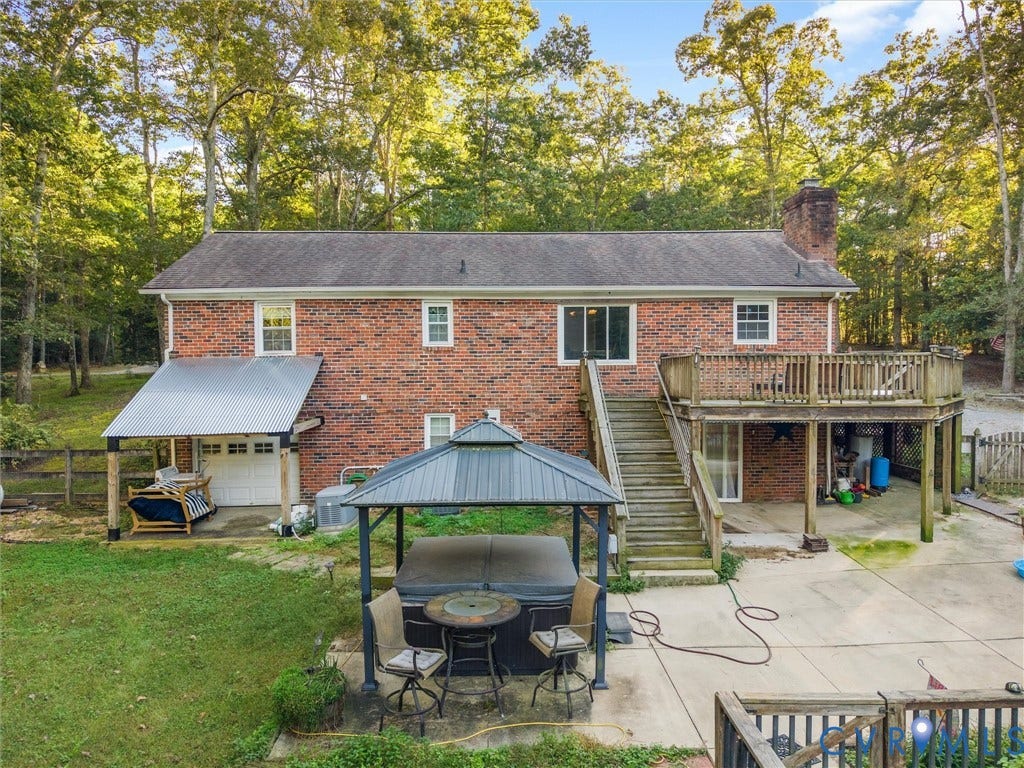8251 Old Roxbury Road, Quinton, VA 23141 Brick exterior residence featuring a wood deck, a metal-roofed patio, a concrete patio area, and a detached gazebo