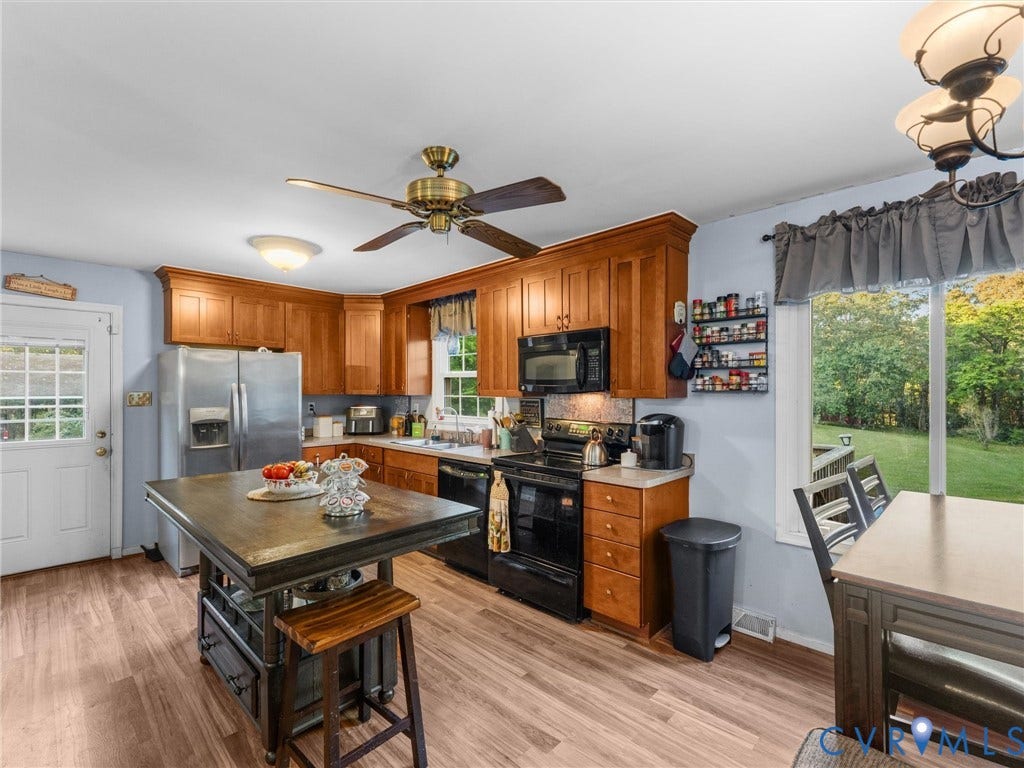 8251 Old Roxbury Road, Quinton, VA 23141 Kitchen featuring wood cabinetry, an island, wood-finish flooring, a ceiling fan, and black appliances
