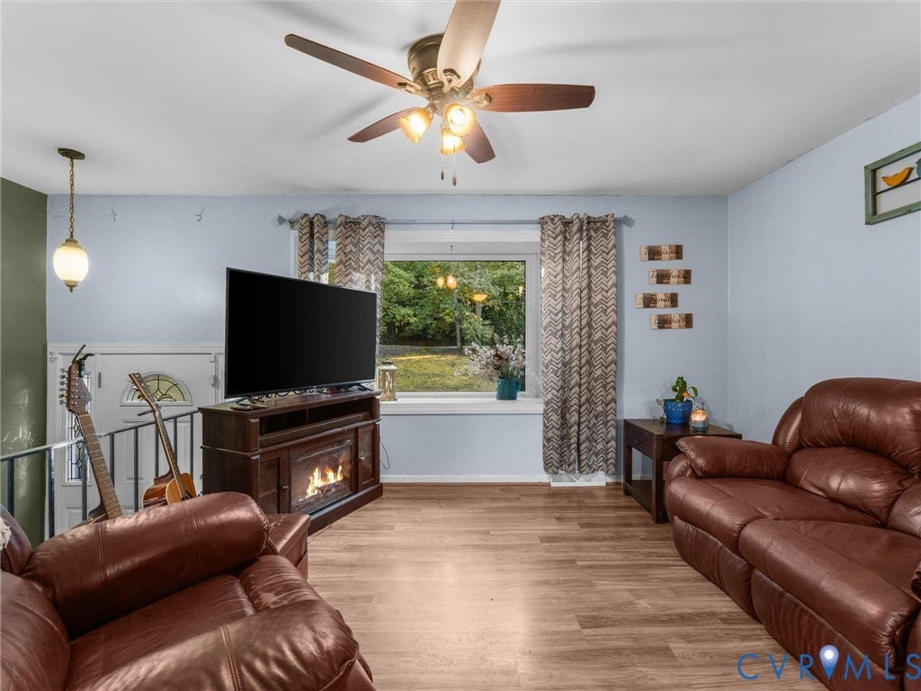 8251 Old Roxbury Road, Quinton, VA 23141 Wood-finish flooring, ceiling fan with integrated lighting, large picture window with sill, and metal railing