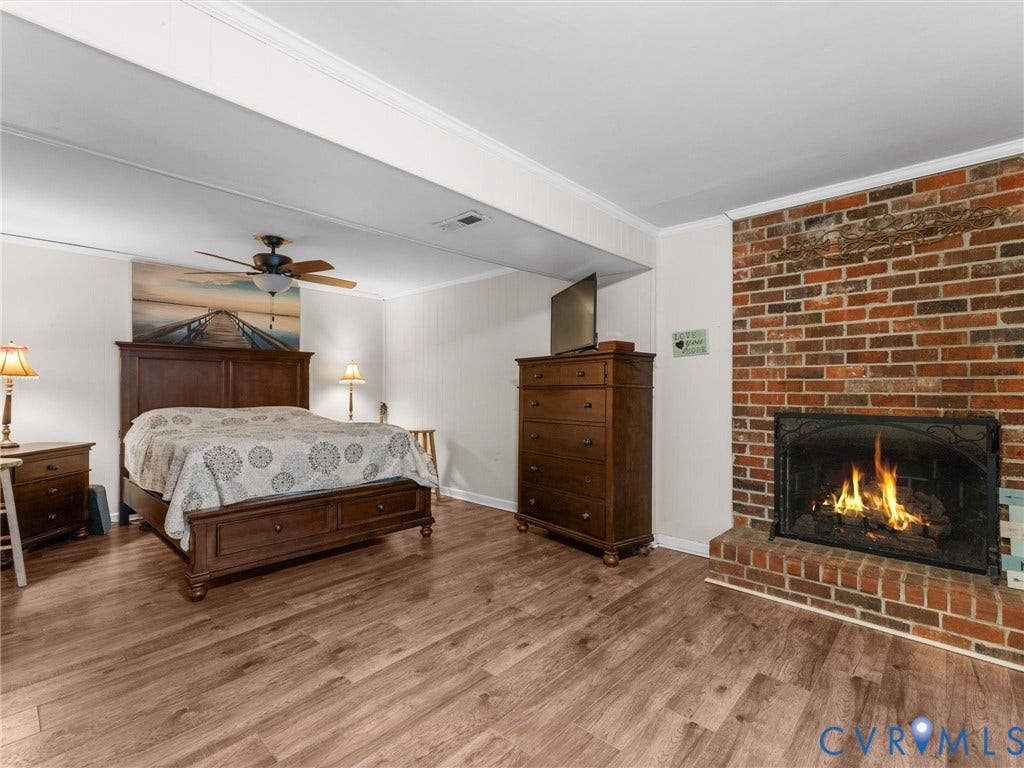 8251 Old Roxbury Road, Quinton, VA 23141 Floor-to-ceiling brick fireplace, wood-finish flooring, and ceiling fan with integrated lighting