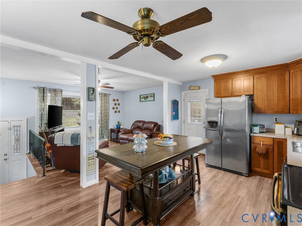 8251 Old Roxbury Road, Quinton, VA 23141 Kitchen featuring wood-finish cabinetry, stainless steel refrigerator, wood-finish flooring, and a ceiling fan with integrated lighting