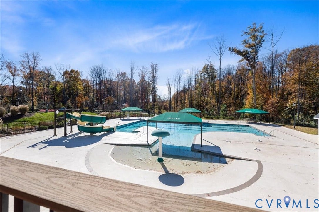 9129 Spring Green Loop, Mechanicsville, VA 23116 Community pool with a water slide, shallow wading area, and multiple shade umbrellas