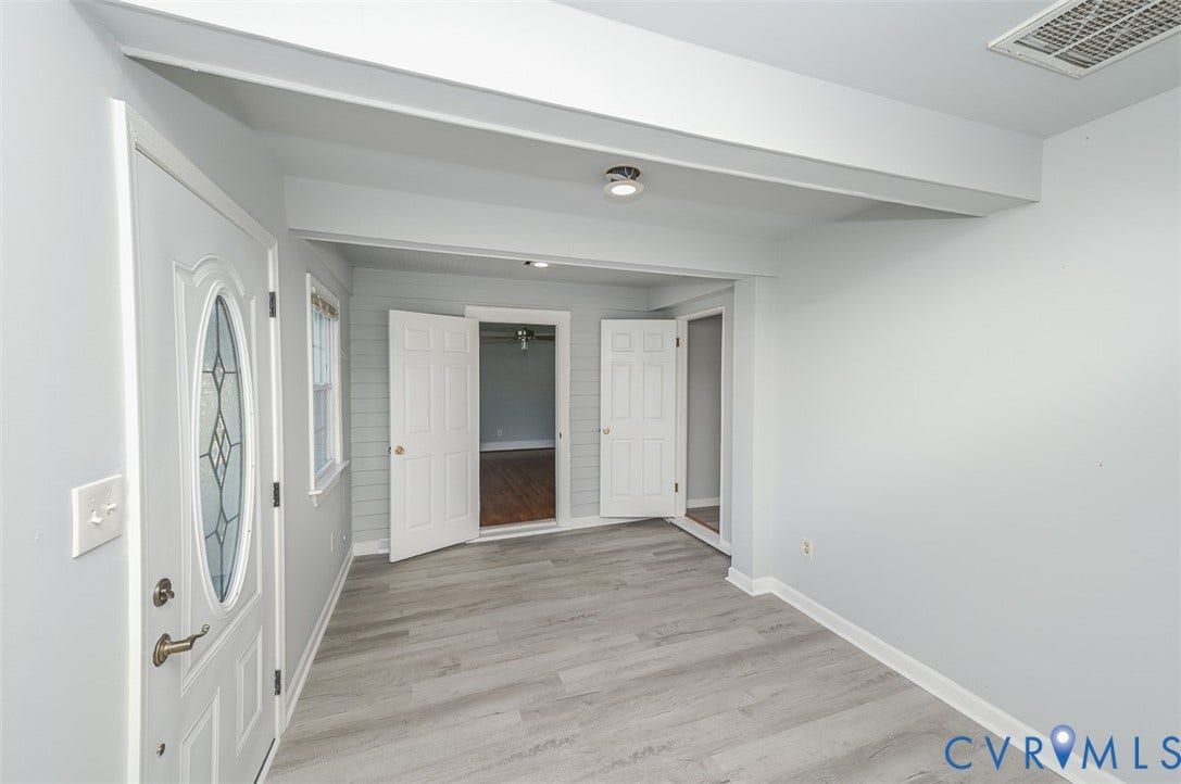 Entryway featuring wood-finish flooring, a decorative glass front door, and painted trim