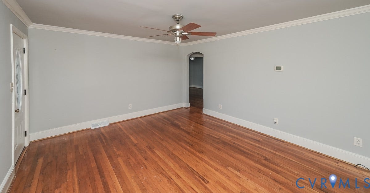Hardwood flooring, crown molding, ceiling fan, arched doorway