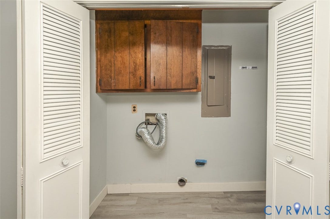 Louvered bi-fold doors reveal a utility area with wood-finish flooring