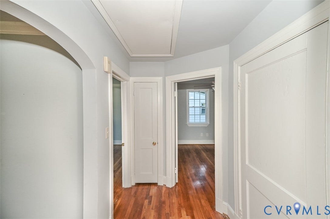 Wood-finish flooring throughout, with white trim and solid doors