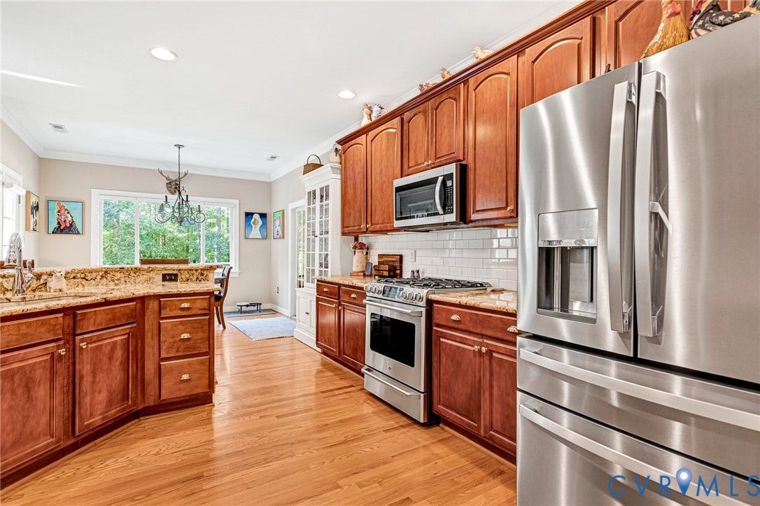 360 Laurel Drive, Aylett, VA 23009 Kitchen featuring wood-finish flooring, stainless steel appliances, wood cabinetry, granite countertops, and a white subway tile backsplash