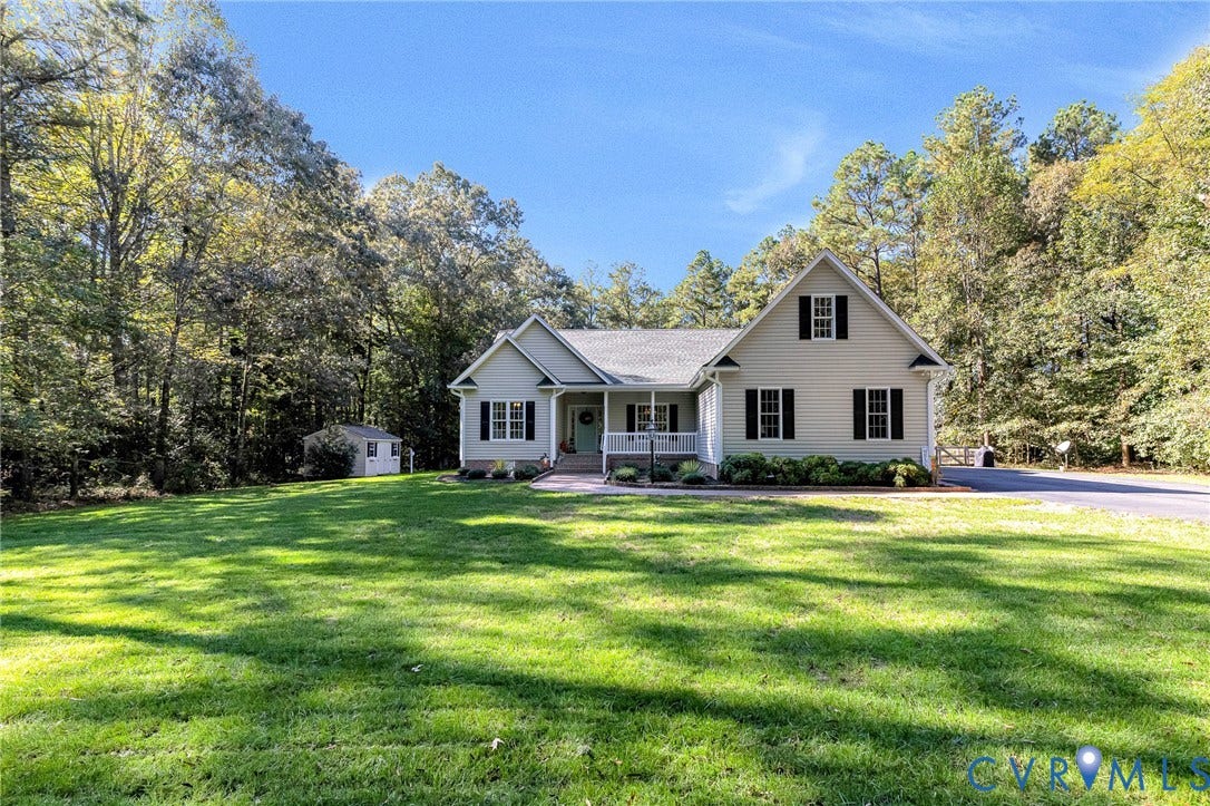 360 Laurel Drive, Aylett, VA 23009 Gabled roofline with dormer window, covered front porch, light-colored siding, dark shutters, and a front yard with mature trees