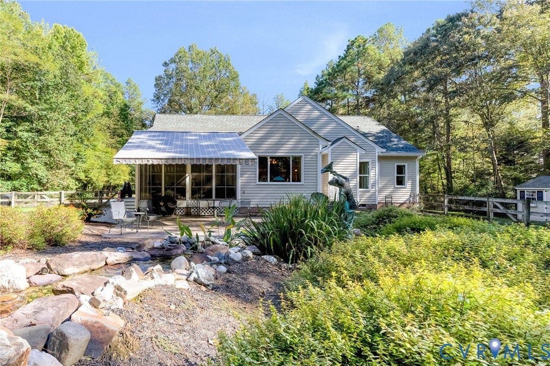 360 Laurel Drive, Aylett, VA 23009 Siding exterior with multiple windows, screened porch, stone landscaping, and a wooden fence