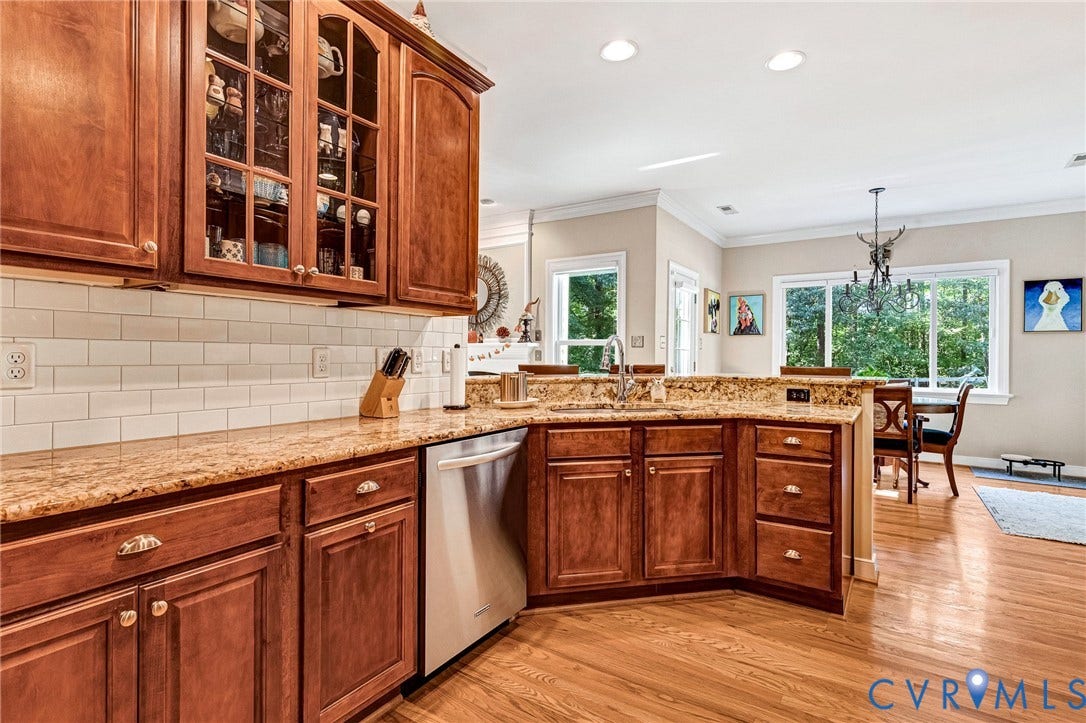 360 Laurel Drive, Aylett, VA 23009 Kitchen featuring wood cabinetry, light-colored countertops, stainless steel dishwasher, and subway tile backsplash