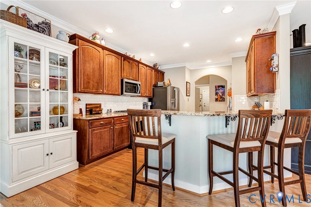 360 Laurel Drive, Aylett, VA 23009 Wood-finish flooring, recessed lighting, white subway tile backsplash, wood cabinetry, and a light-toned countertop