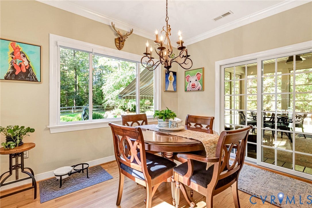 360 Laurel Drive, Aylett, VA 23009 Hardwood flooring, crown molding, large window, sliding glass patio door, and a decorative chandelier