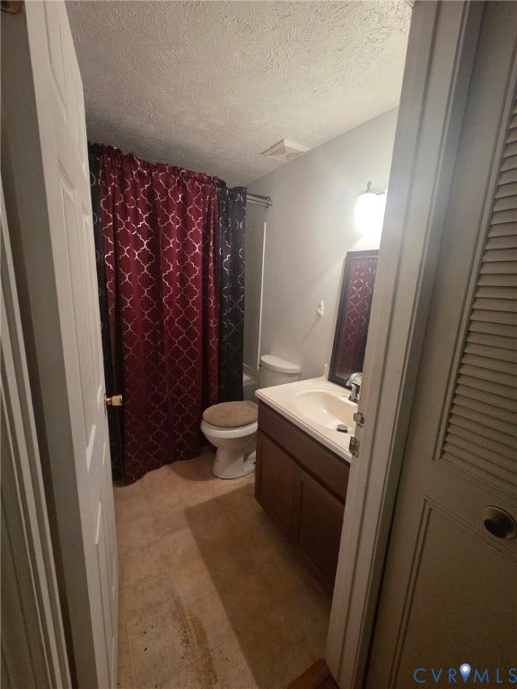 6521 S Stevens Hollow Drive, North Chesterfield, VA 23832 Bathroom featuring a vanity with a white countertop and integrated sink, wood-finish cabinetry, and a wall-mounted light fixture