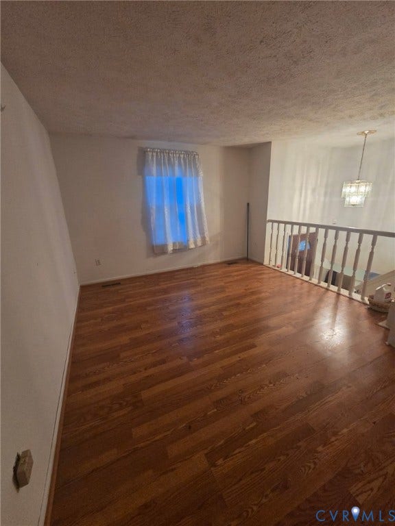 6521 S Stevens Hollow Drive, North Chesterfield, VA 23832 Hardwood flooring, white painted walls, window with sheer curtains, banister, and a tiered chandelier