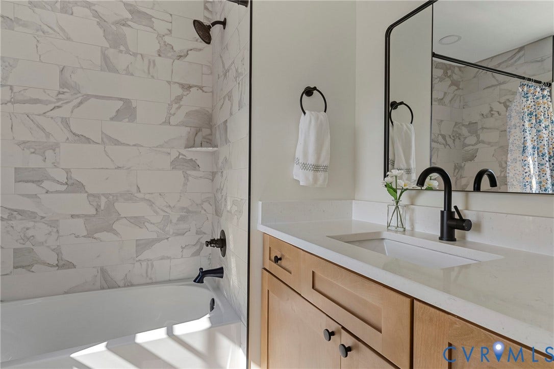 2601 Greenway Avenue, Lakeside, Henrico, VA 23228 Bathroom featuring a natural-finish wood vanity, white solid-surface countertop, matte black fixtures, and a tub-shower combination with rectified-edge tile surround