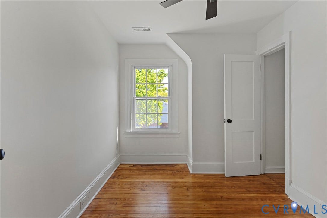 2601 Greenway Avenue, Lakeside, Henrico, VA 23228 Interior room featuring wood-finish flooring, a multi-pane window with detailed trim, a two-panel interior door with dark hardware, and a ceiling-mounted fan
