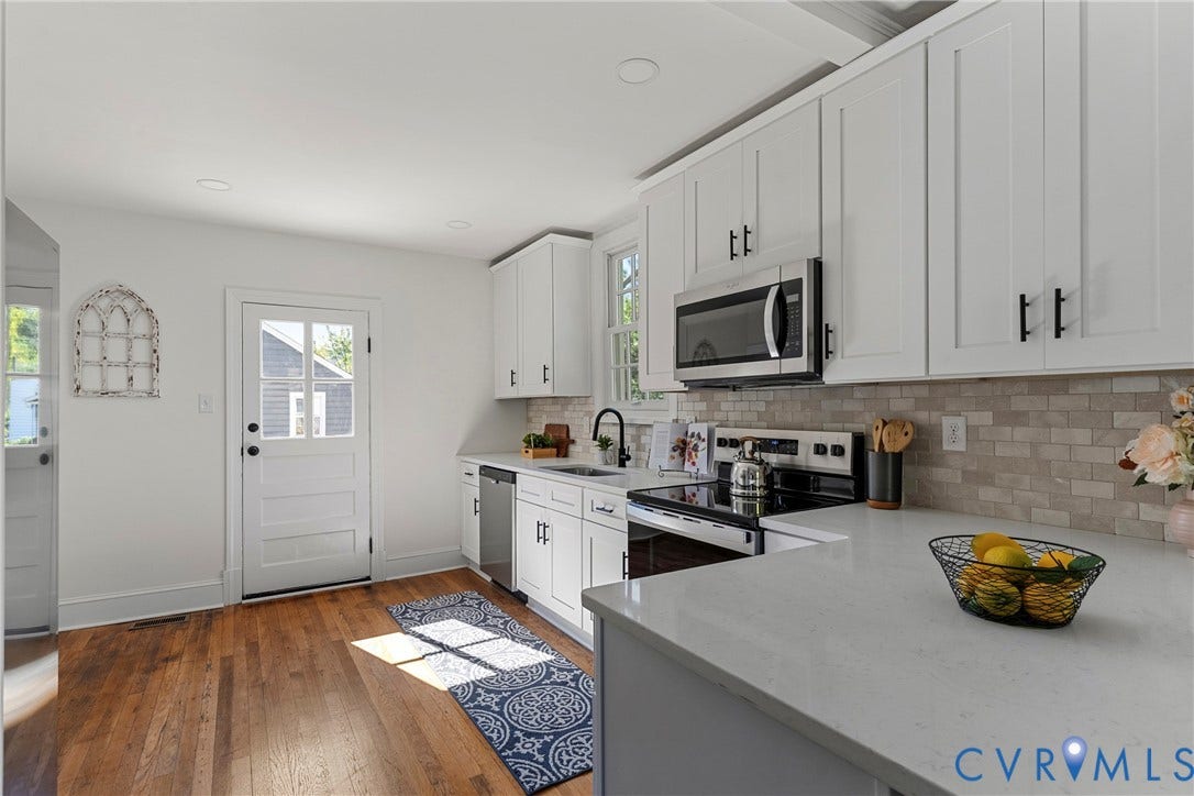 2601 Greenway Avenue, Lakeside, Henrico, VA 23228 Kitchen featuring white shaker-style cabinetry, solid-surface countertops, a neutral-toned tile backsplash, stainless steel appliances, and wood-finish flooring