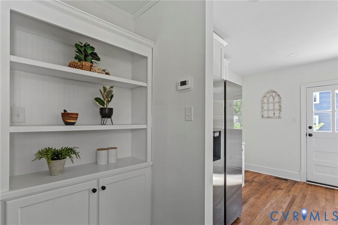 2601 Greenway Avenue, Lakeside, Henrico, VA 23228 Built-in floor-to-ceiling white cabinetry with open shelving, wood-finish flooring, stainless steel refrigerator, and paneled exterior door