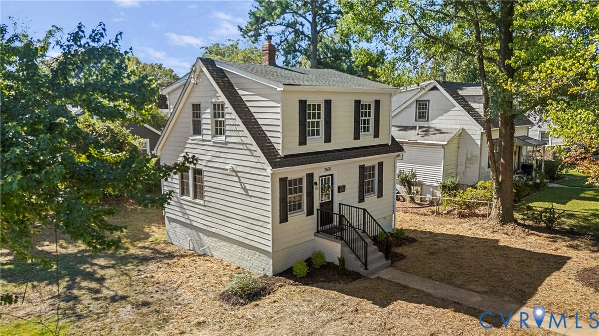 2601 Greenway Avenue, Lakeside, Henrico, VA 23228 Two-story residence featuring light-colored horizontal siding, a gambrel roofline with an integrated chimney, dark window shutters, and a front entry staircase with metal railings