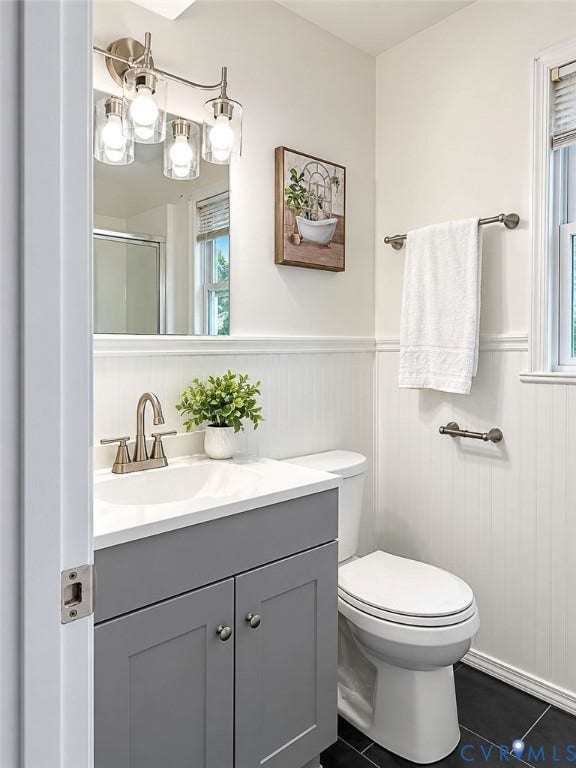 Vanity with gray cabinetry, white countertop, and brushed nickel faucet
