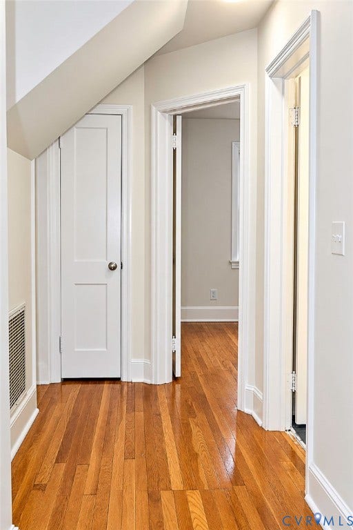 Hardwood flooring throughout, white trim, and white doors